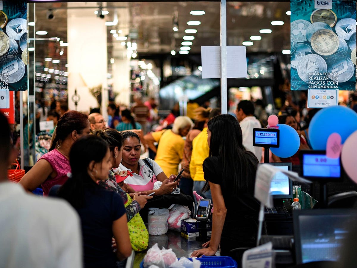 Vendors at a busy Latin American street market accepting stablecoin card payments from customers, highlighting digital finance adoption in the region.