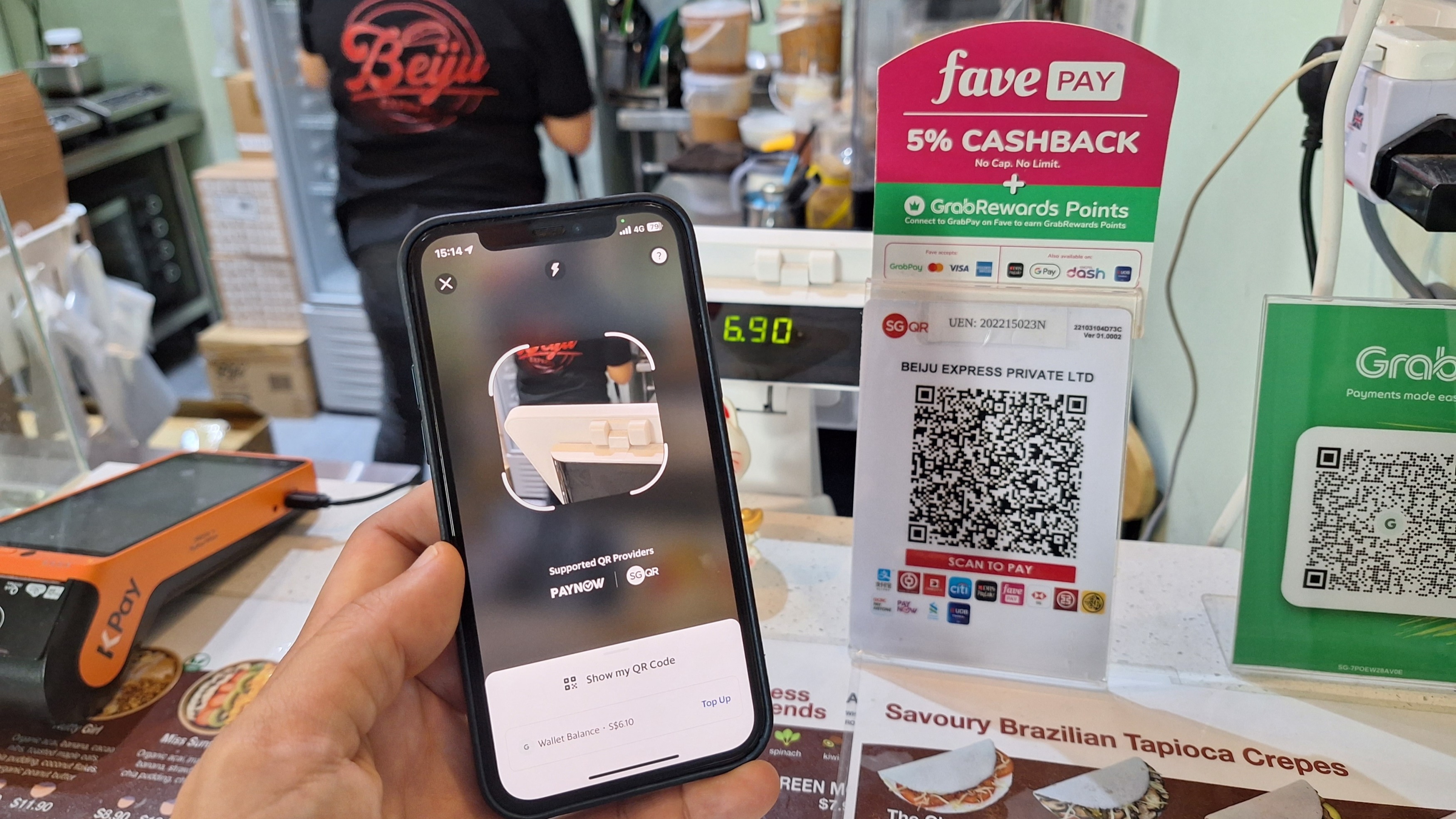 Merchant counter with QR code for stablecoin payments next to traditional POS terminals, illustrating GENIUS Act 2025 compliance