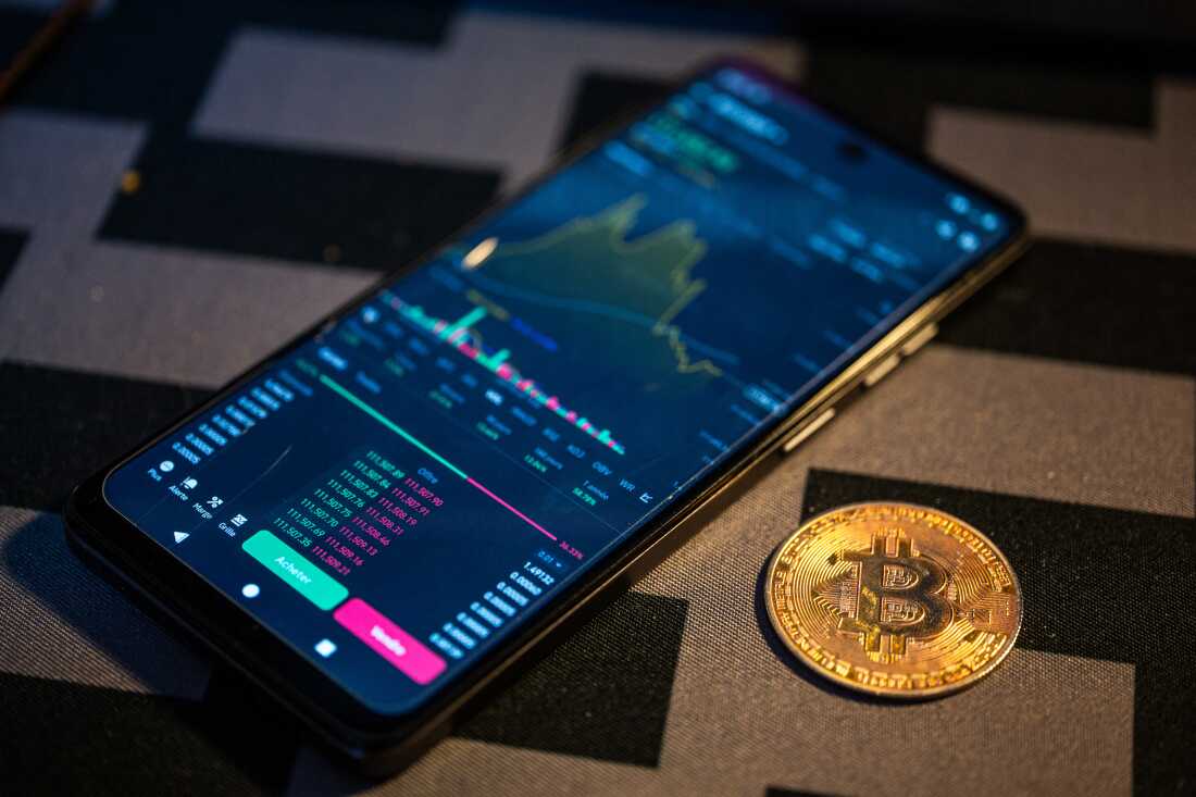Close-up of a digital US dollar coin next to a DeFi app interface on a smartphone, symbolizing new stablecoin regulations under the GENIUS Act