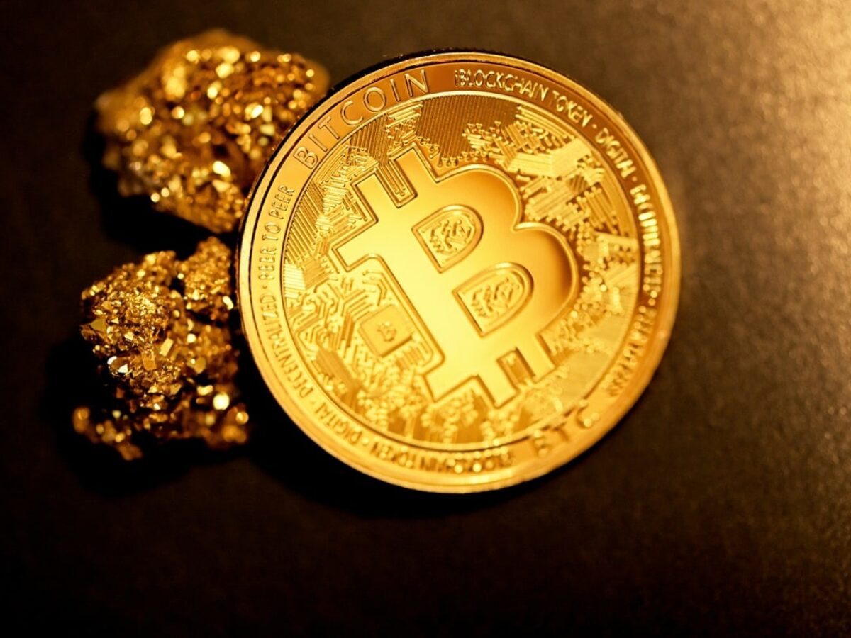 Close-up of tokenized gold coins next to a digital wallet app on a smartphone, illustrating modern gold investment methods in 2024.