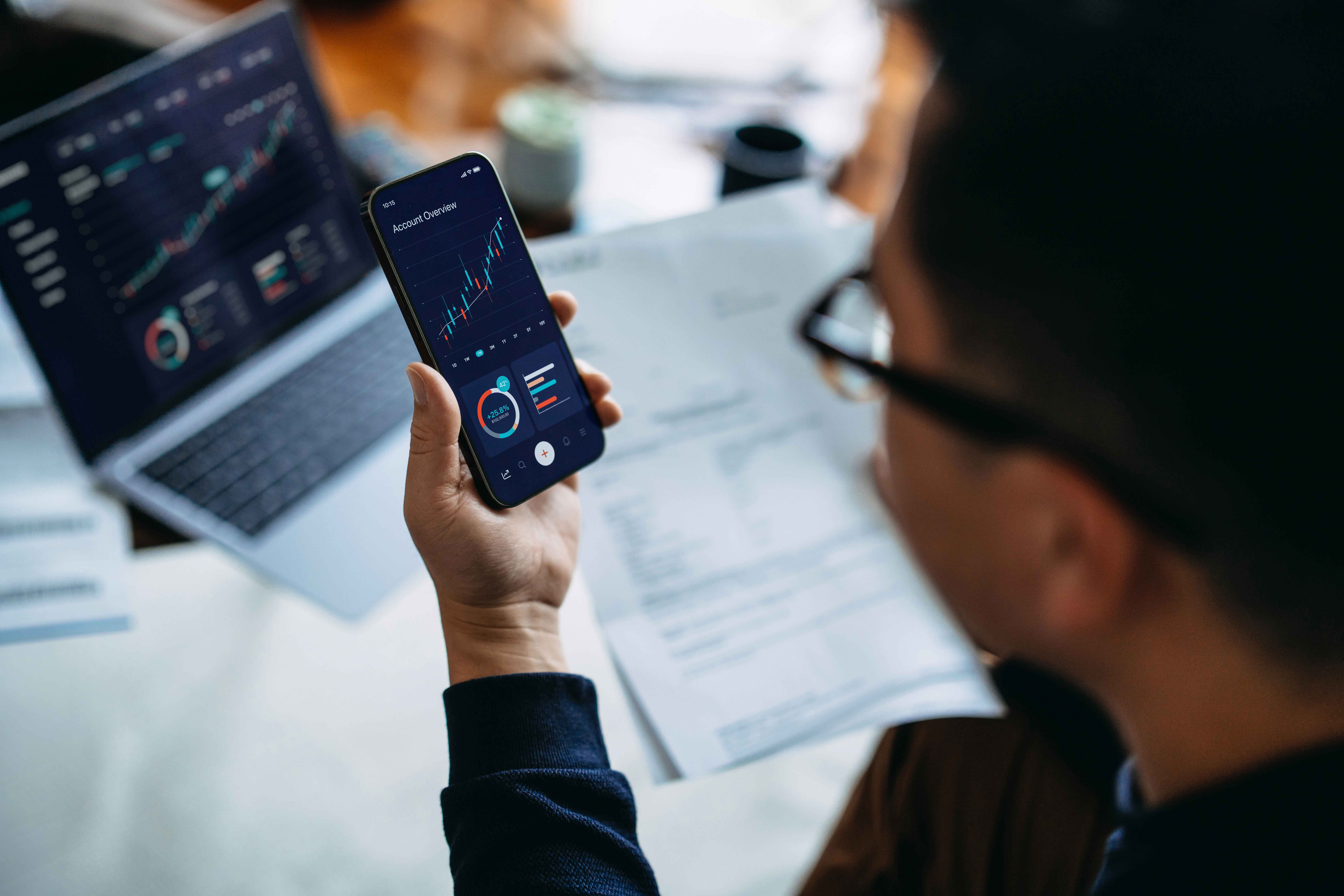 Diverse global investors analyzing digital real estate token portfolios on laptops and smartphones