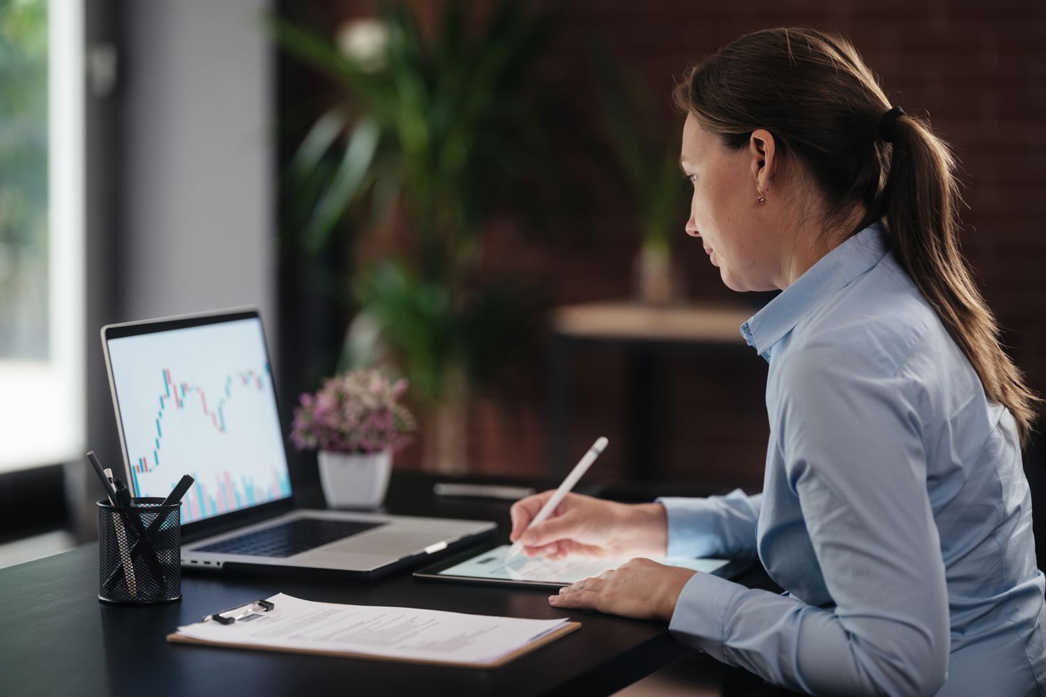 Diverse group of professionals discussing cryptocurrency investment options on digital devices in a modern office setting