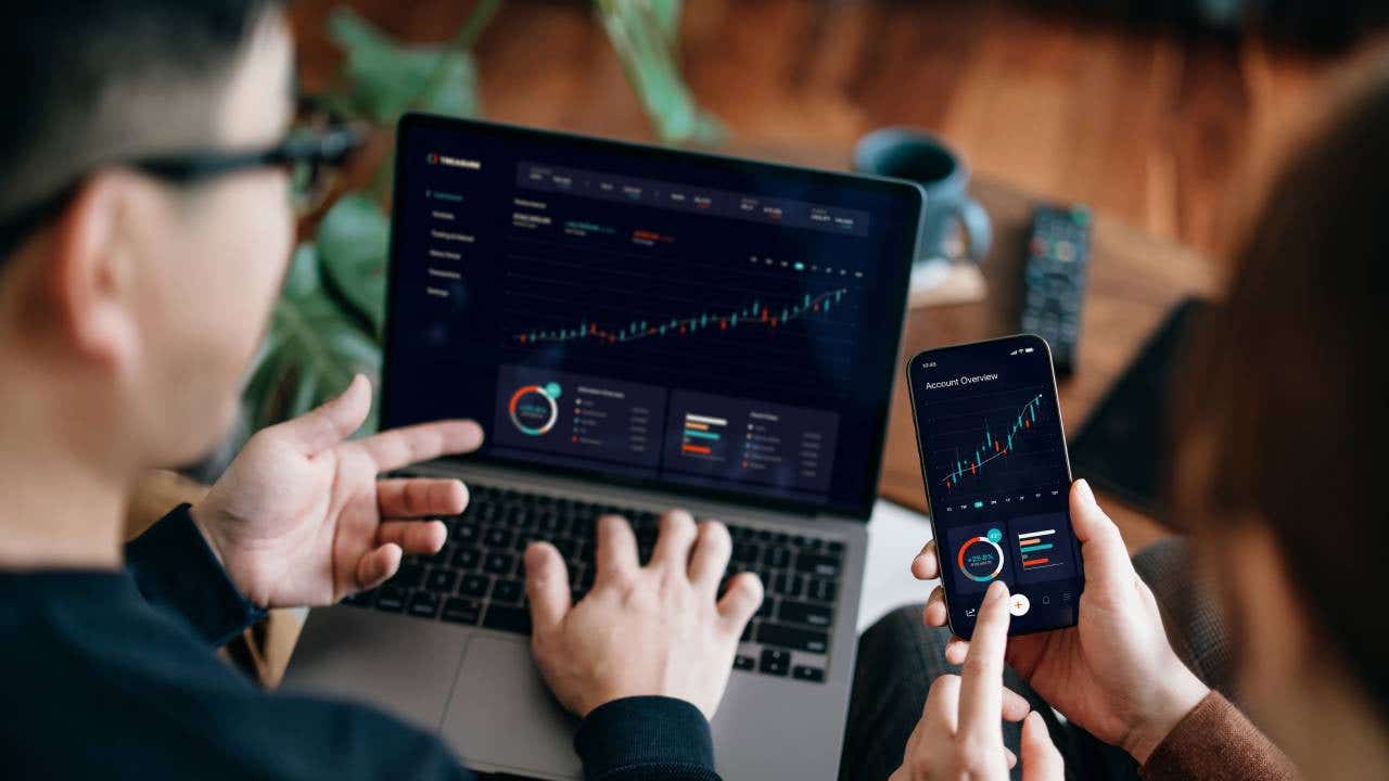 Diverse young investors using laptops and smartphones to explore tokenized real estate investment platforms, representing a step-by-step guide for beginners.