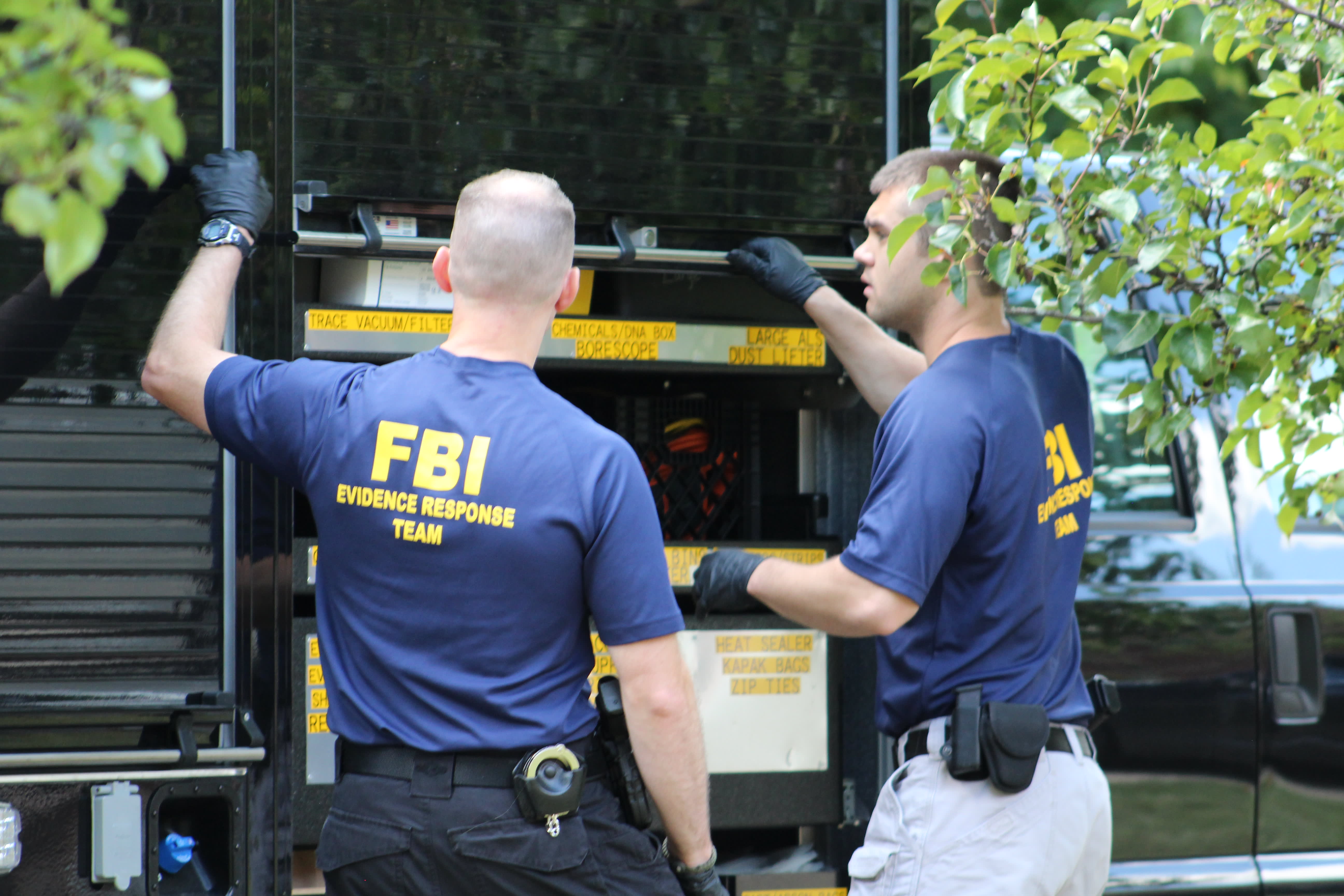 Law enforcement agents display seized hardware wallets and paperwork after record Bitcoin fraud bust