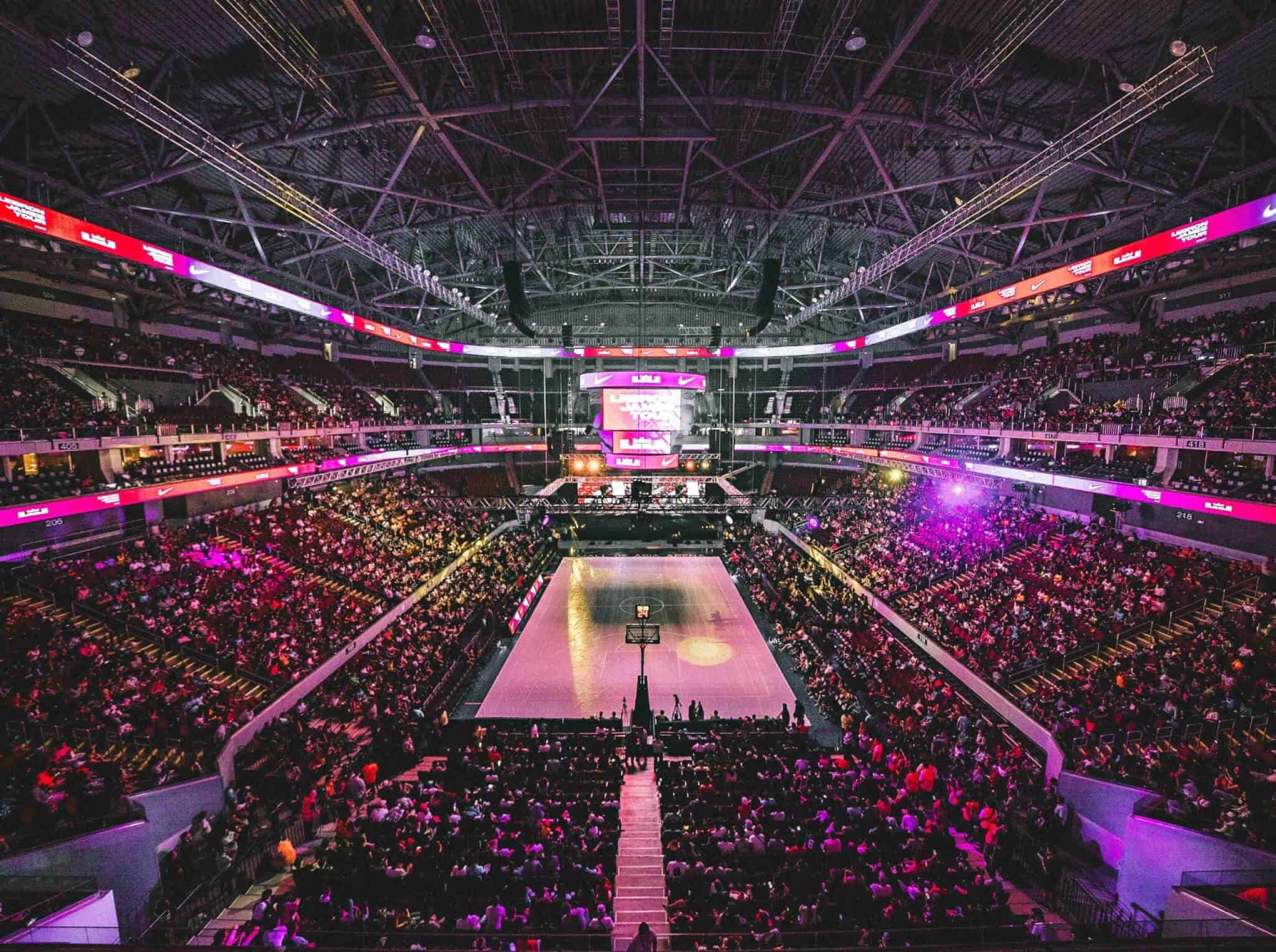 Dynamic stadium scene with athletes and fans, digital assets and NFTs floating above, representing programmable sports IP on blockchain in 2025