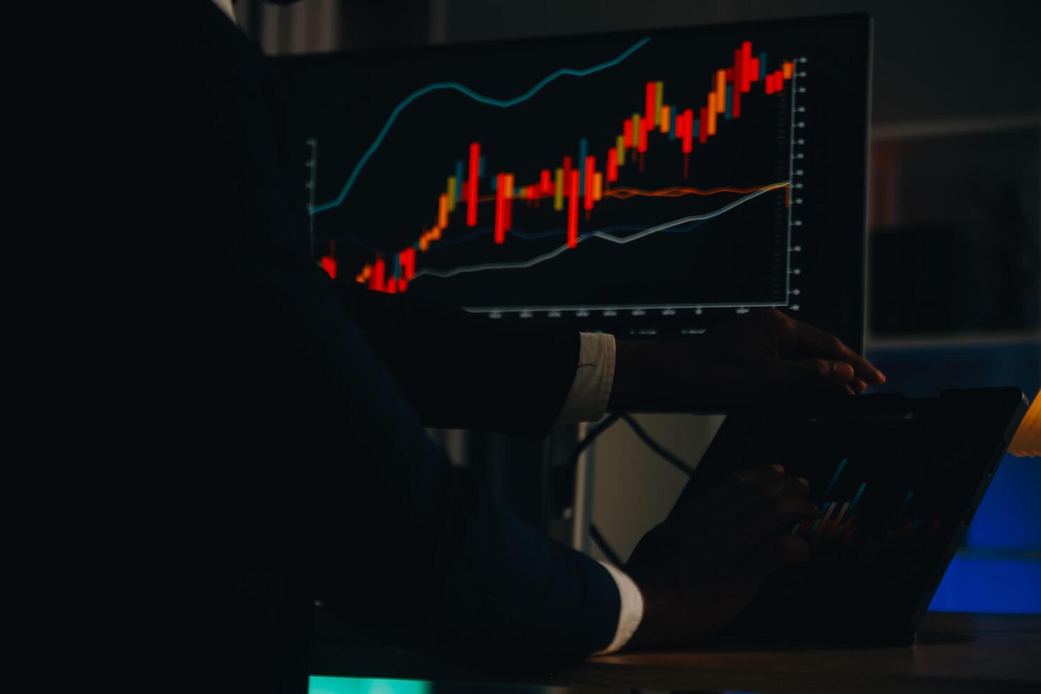 Focused crypto trader analyzing digital charts on a laptop at night in a dimly lit room, emphasizing concentration and technology-driven trading.