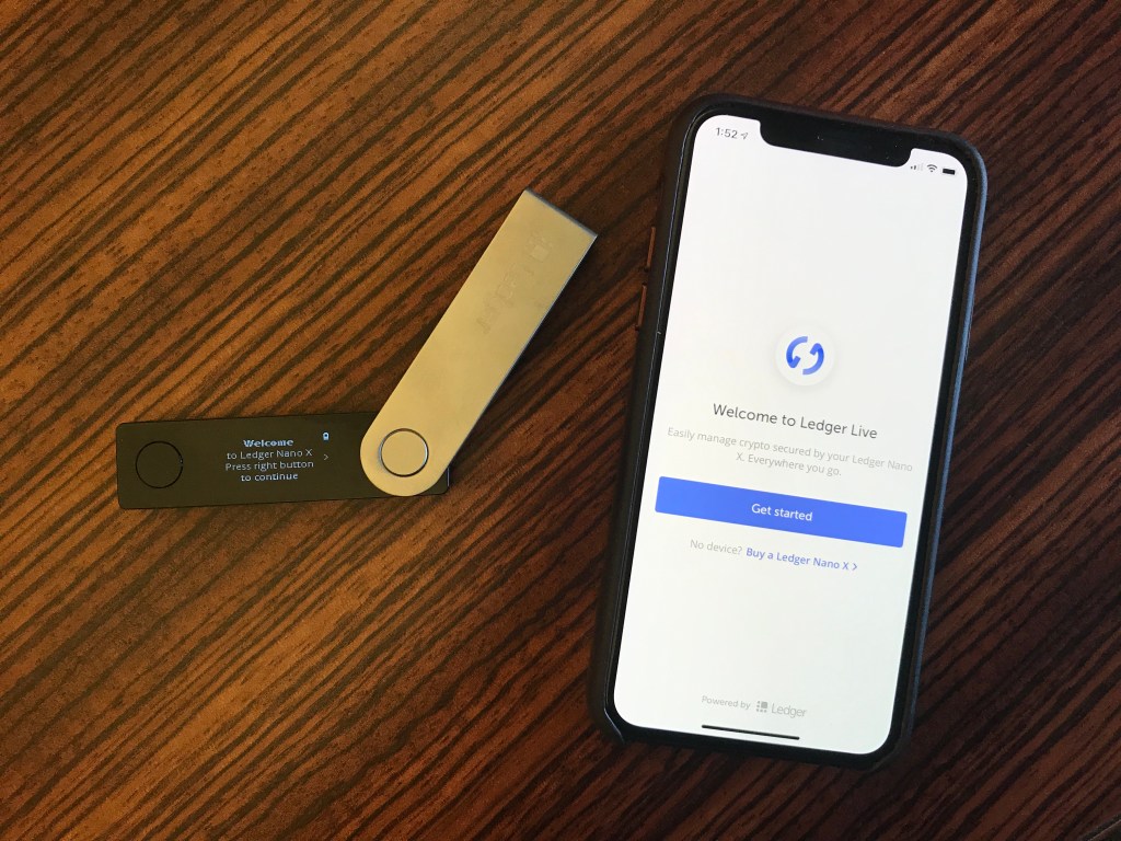High-security hardware wallet beside a smartphone showing Bitcoin wallet app, symbolizing digital asset security and crypto safety in 2025