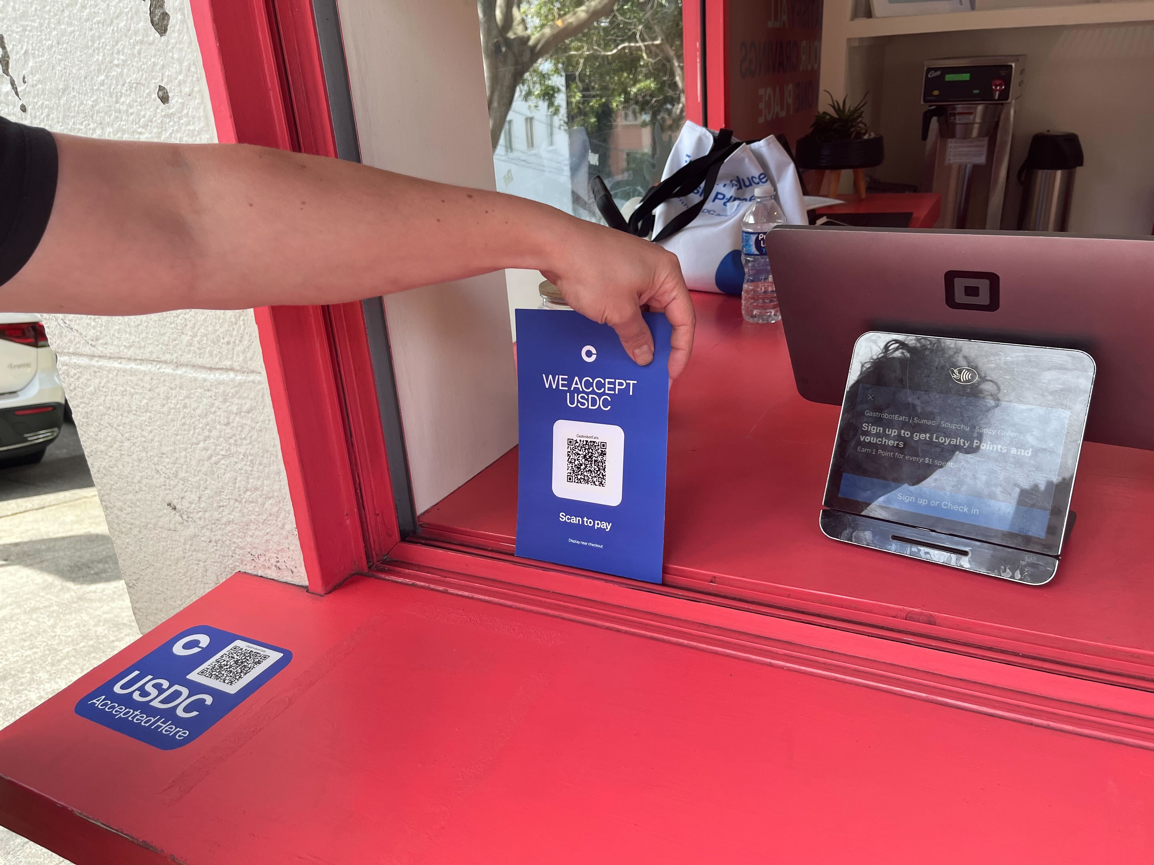 Merchant at a live event accepting USDC payments using Base Pay on a mobile device