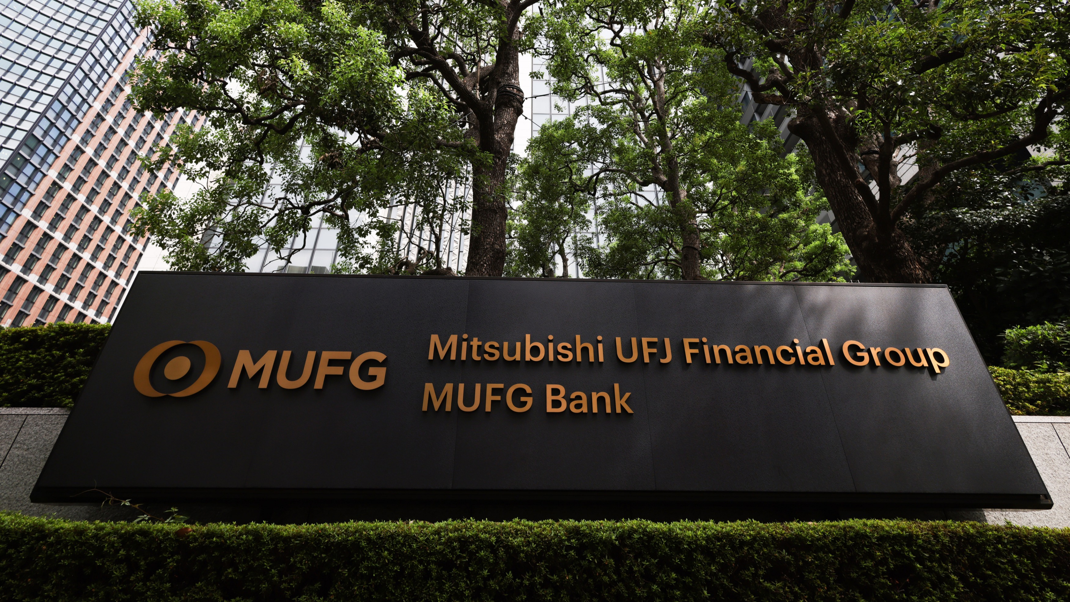 Panoramic view of Tokyo financial district with MUFG, SMFG, and Mizuho bank logos superimposed, representing Japan's major banks launching yen-backed stablecoins
