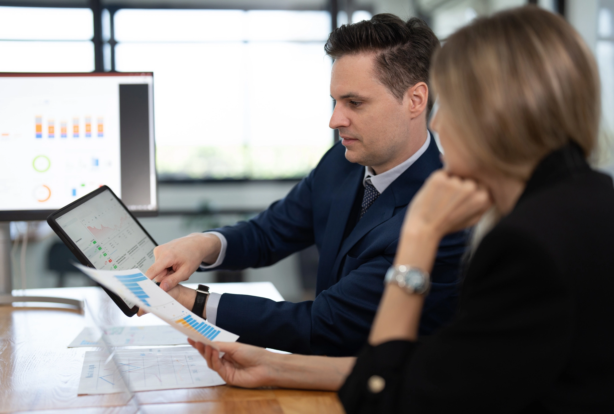 Diverse group of professionals discussing 401(k) investment options with digital screens displaying cryptocurrency trends, reflecting Trump's executive order on crypto in retirement plans.