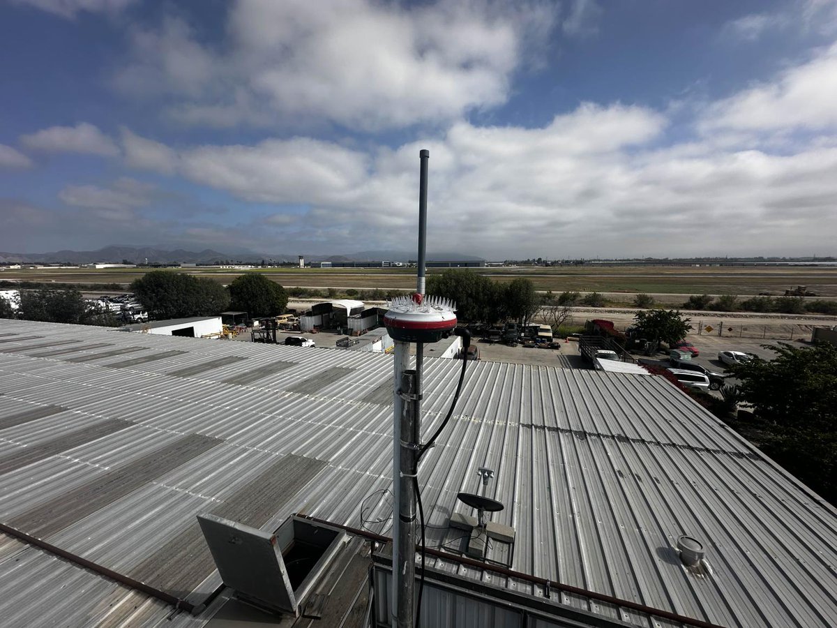 Wingbits rooftop antenna setup capturing ADS-B flight data with a city skyline in the background