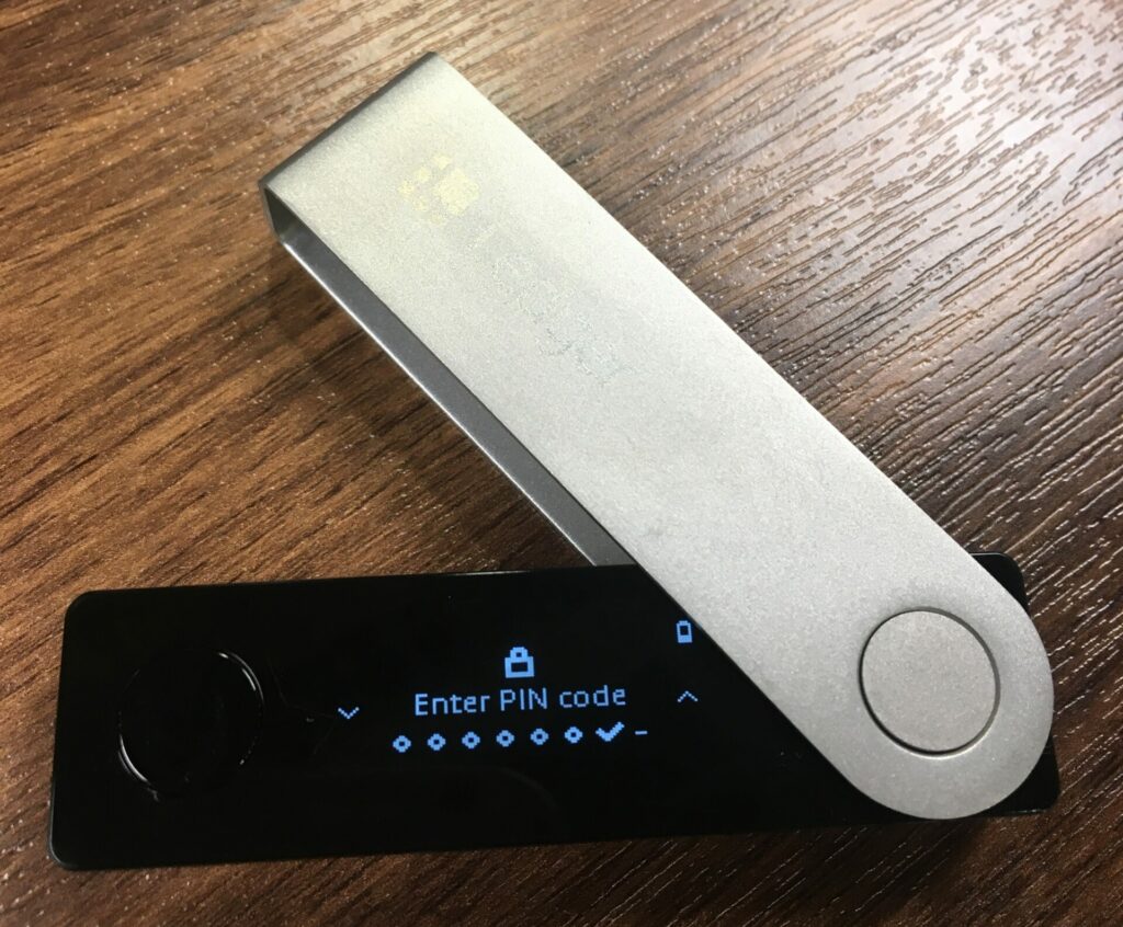 MetaMask Card and Ledger Nano X hardware wallet side by side on a dark background, showcasing top crypto wallet options for 2025