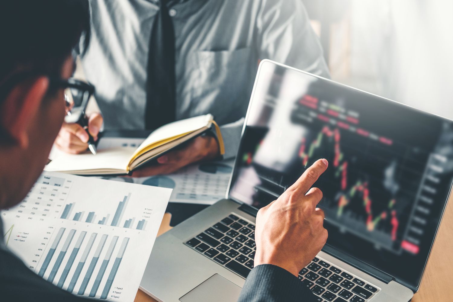 Thoughtful investor analyzing Bitcoin trends on a laptop in a modern workspace, representing strategic crypto decision-making in a volatile market.