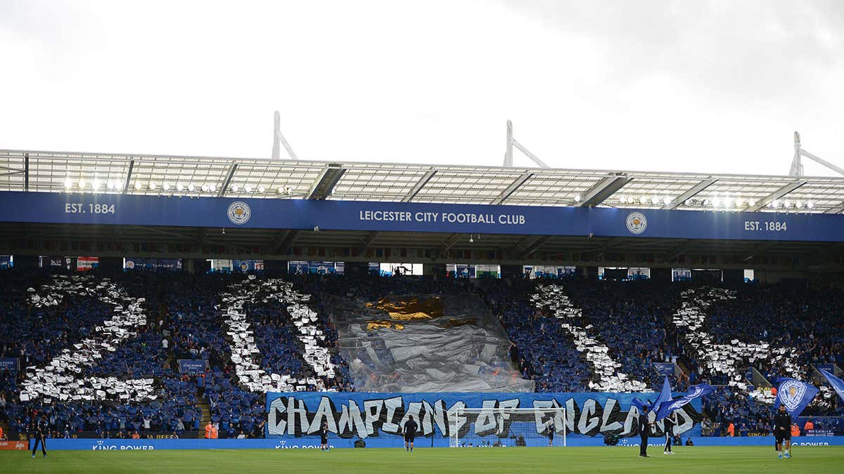Football fans in a stadium holding smartphones showing club fan token apps, illustrating global digital fan engagement in 2025