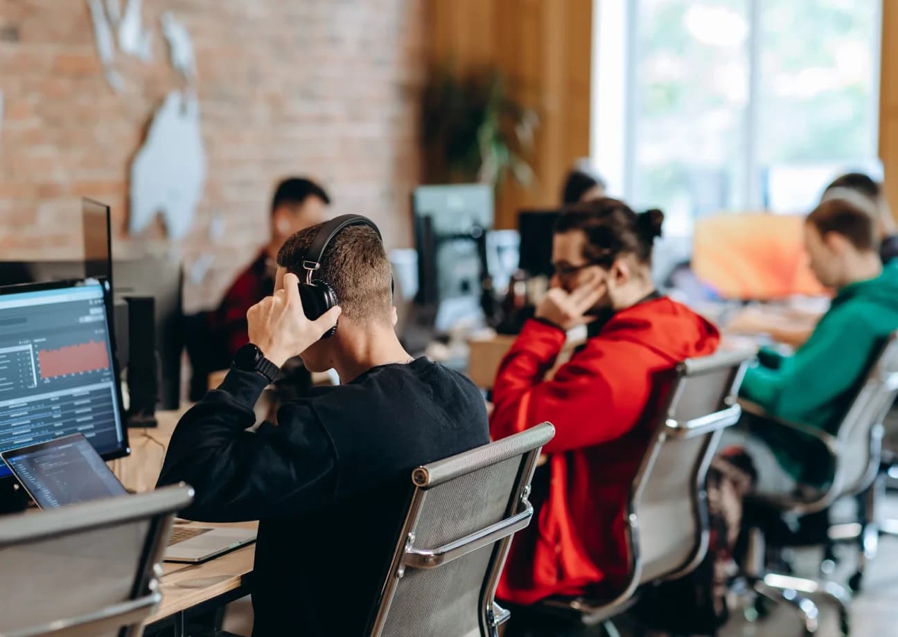 Diverse group of gamers collaborating at digital terminals in a fully on-chain blockchain game community