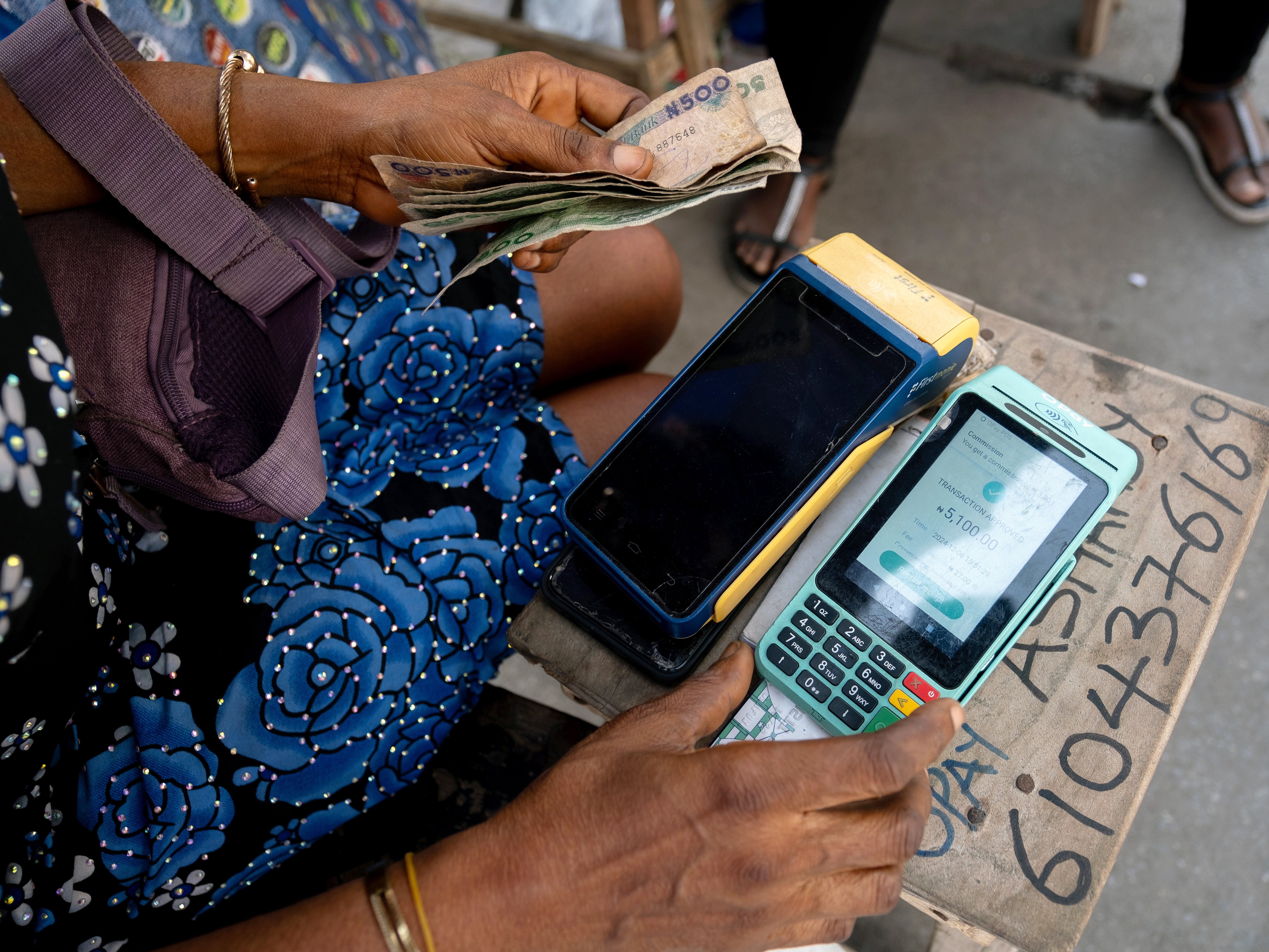Lagos market merchants using smartphones for digital payments in a vibrant African marketplace, showcasing fintech adoption in Nigeria.