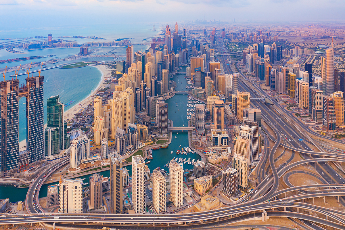 Aerial view of London and Dubai skylines overlaid with blockchain tokens representing fractional real estate ownership via platforms like Stoneform