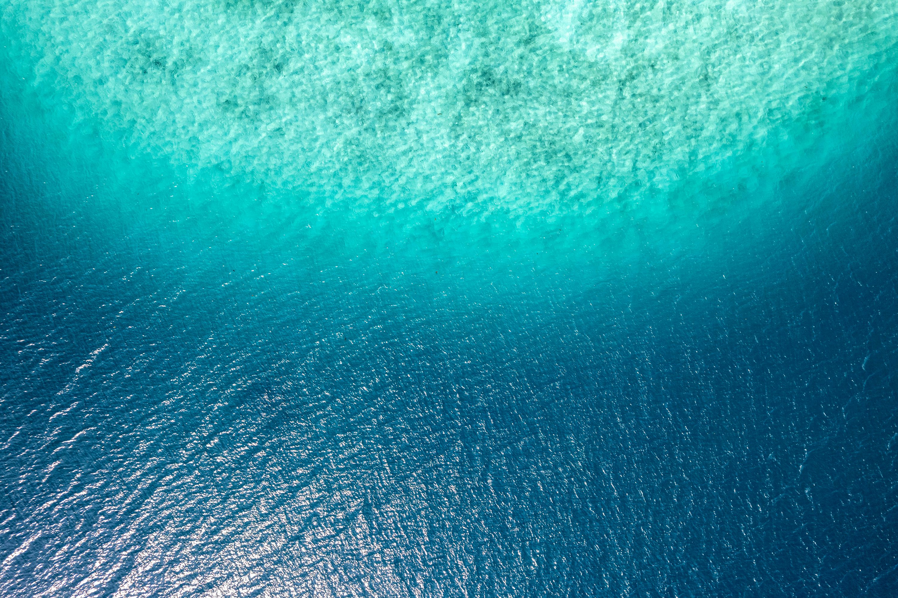 Aerial view of Southeast Asian flights departing over turquoise waters with USDT stablecoin payment icons and glowing on-chain insurance shields for crypto travel bookings