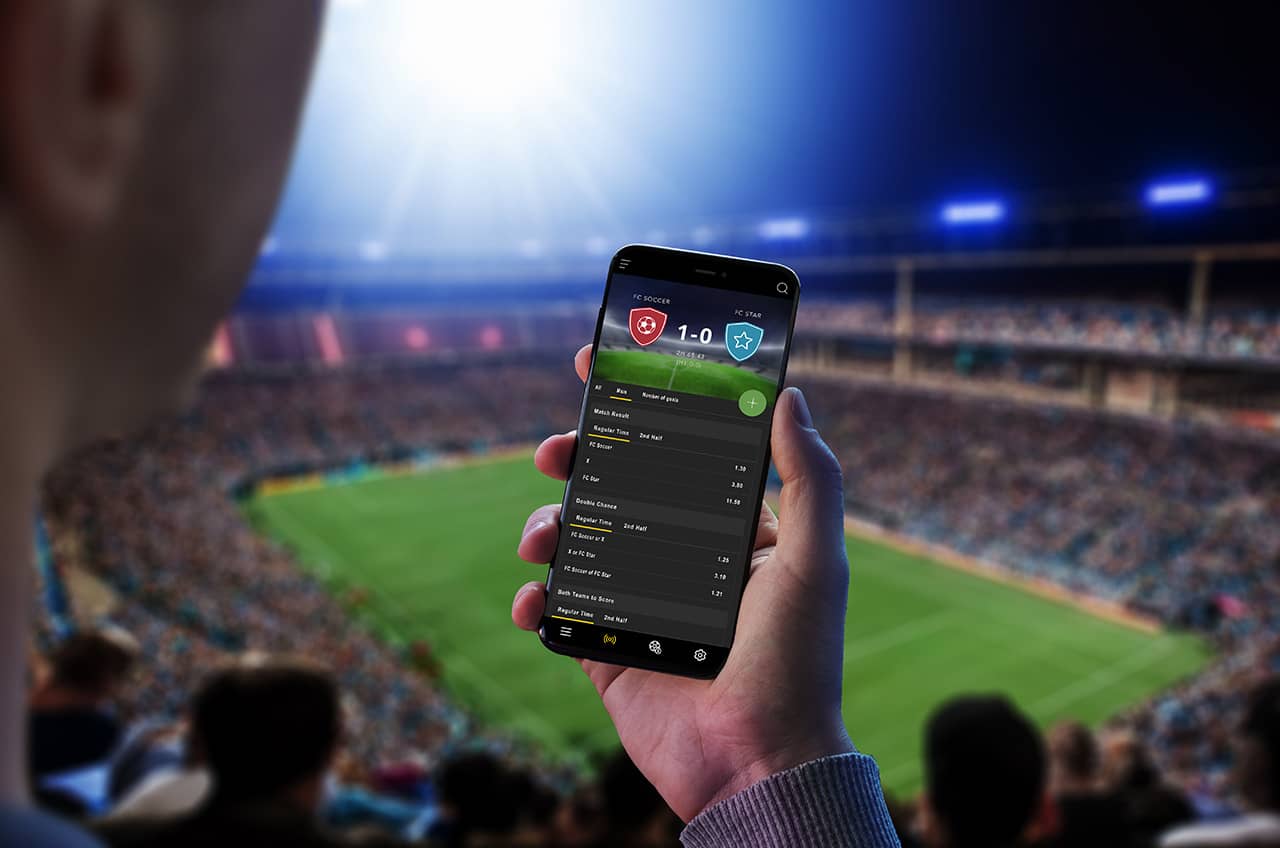 Soccer fans celebrating in a stadium, holding up smartphones displaying digital fan tokens on their screens