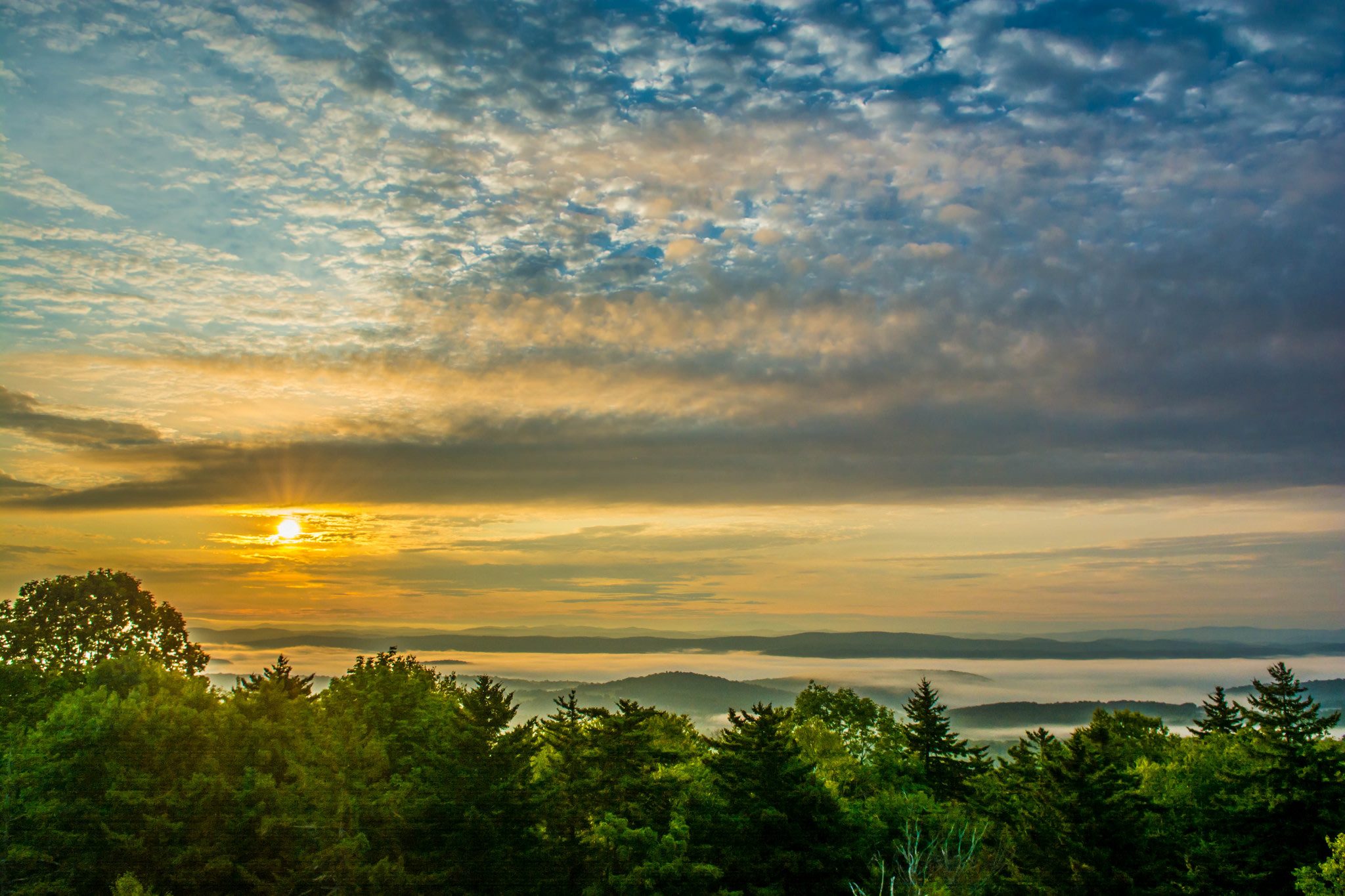 Diverse group of Base chain builders posing together at sunset in Stowe, Vermont during BaseCamp 2025