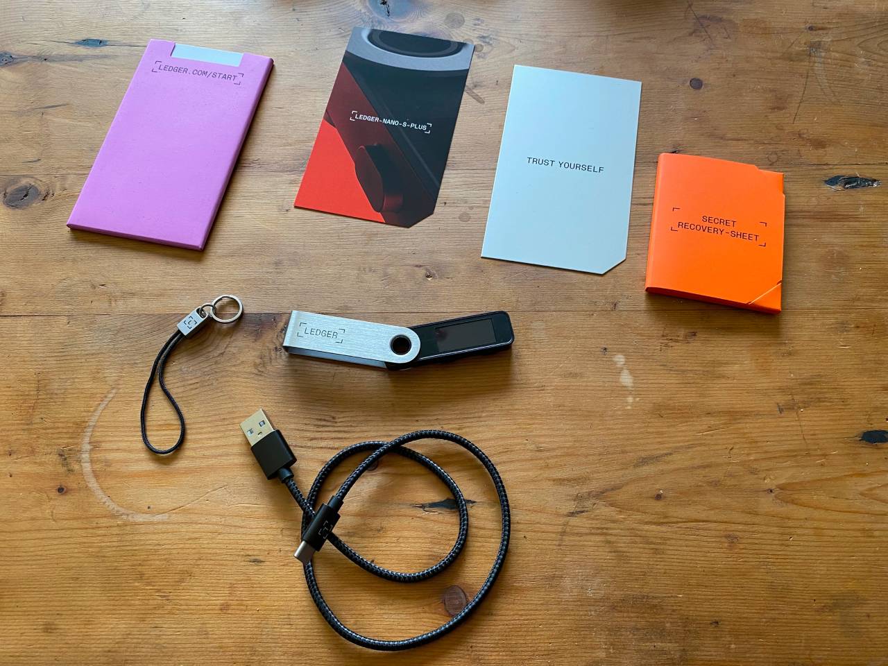 Ledger Nano S Plus hardware wallet next to Trust Wallet mobile app interface for crypto storage comparison