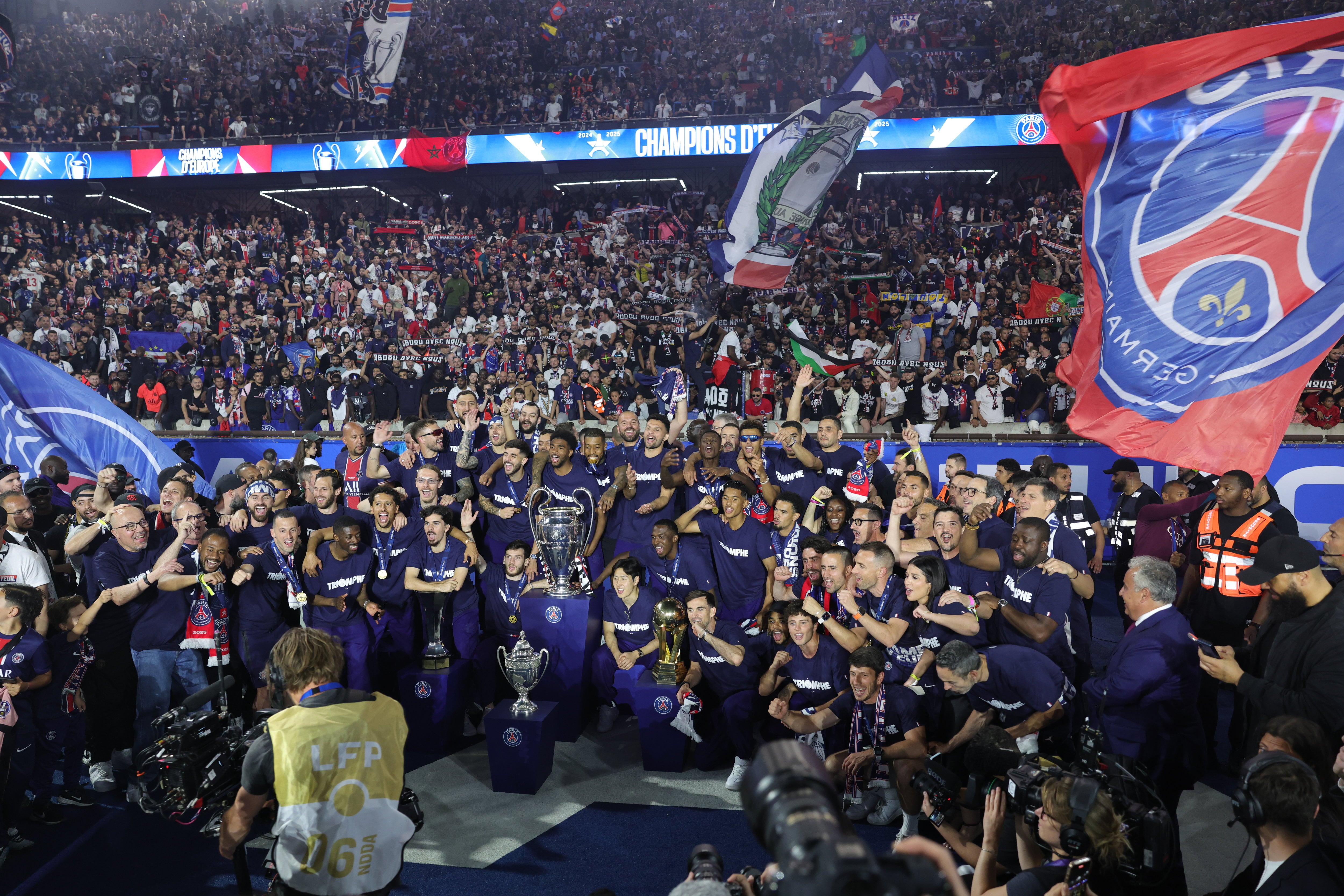 PSG fans celebrating at Parc des Princes, holding up smartphones to capture the moment and engage digitally, showcasing the impact of the PSG Fan Token on football fandom