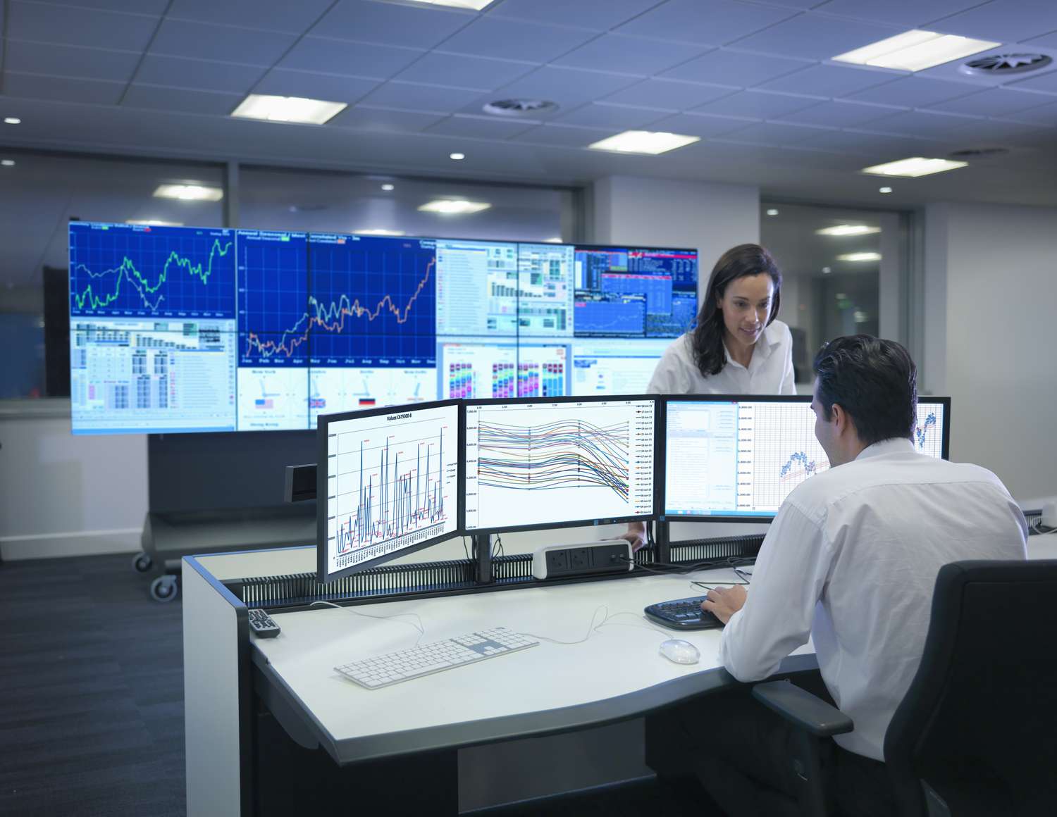 Retirement planner analyzing cryptocurrency portfolio allocation on dual monitors in a modern office setting