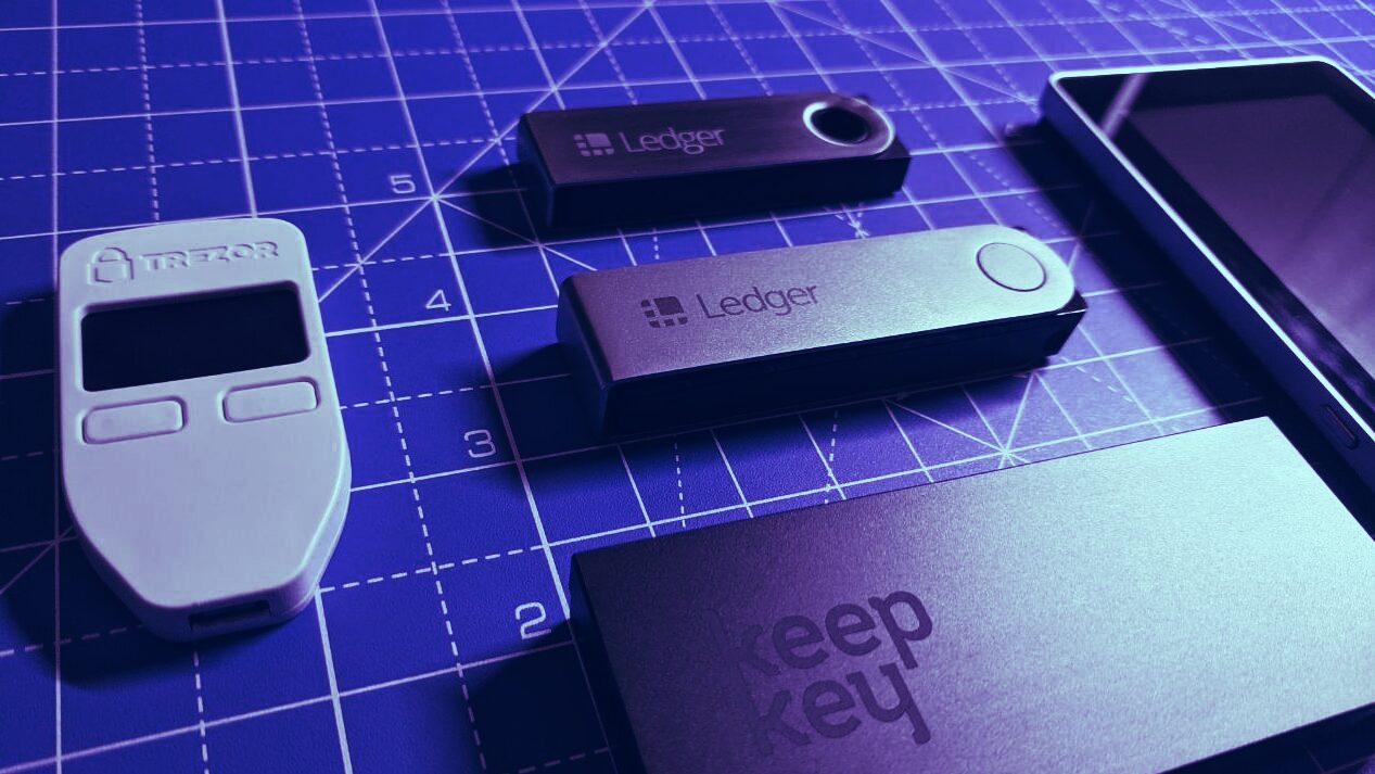 Side-by-side unboxing of Ledger Nano Gen 5 and Trezor Safe 7 hardware wallets with all included accessories displayed