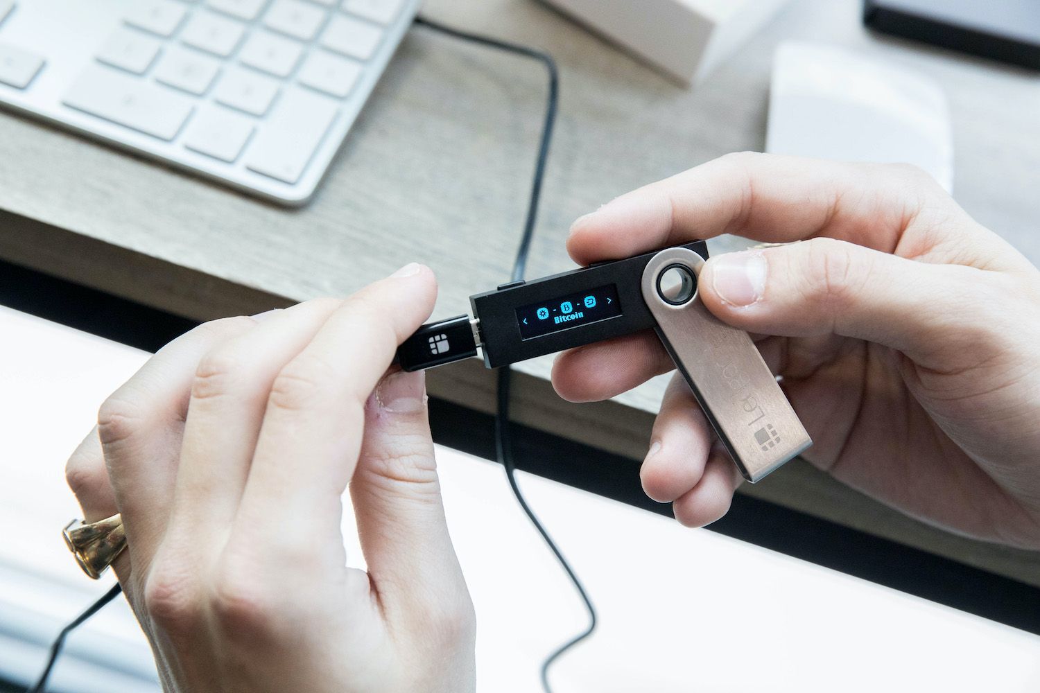 Sleek Ledger Nano X hardware wallet displaying Bitcoin BTC balance on screen, secure crypto storage solution amid IPO news and post-breach security