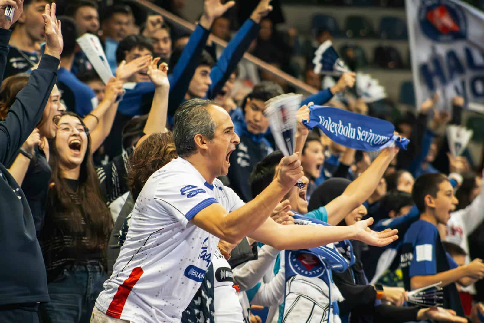 Soccer fans in a stadium using mobile apps to vote with fan tokens, showcasing digital fan engagement and interactive matchday experiences.