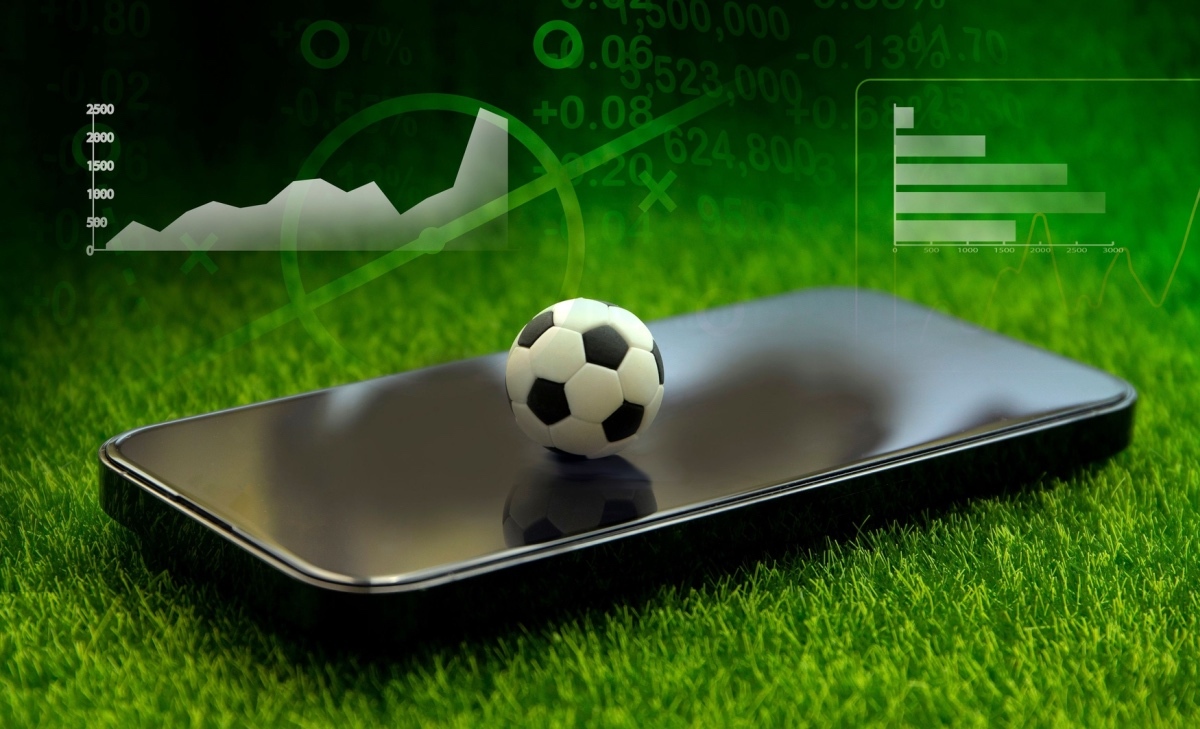 Soccer match action shot with blockchain prediction market odds overlay for over 0.5 goals high-probability bet