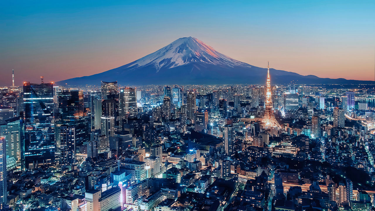 Vibrant aerial view of Tokyo skyline at dusk with overlaid blockchain tokens illustrating fractional ownership in tokenized real estate properties