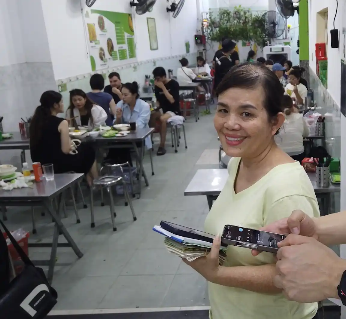 Vibrant Buenos Aires street market vendor displaying USDT QR code on smartphone for offline stablecoin payment, customer scanning with phone showing no internet signal