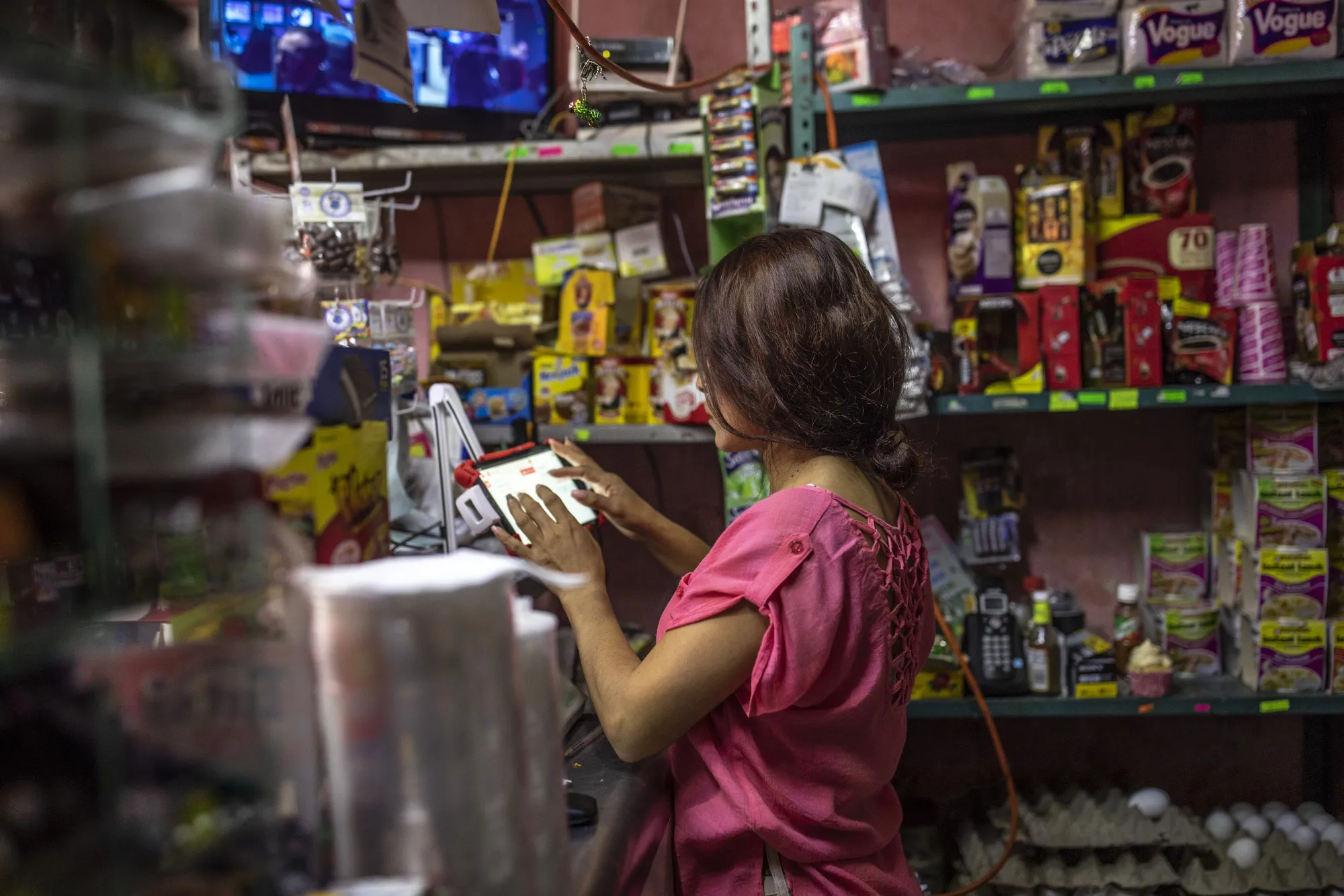 Shopper using virtual stablecoin off-ramp card for fast private fiat payments at bustling Latin American street market